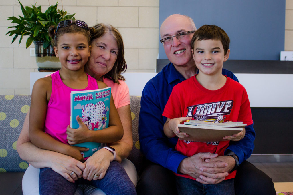 Kaden (right) donates coloring books, crayons and paints to the pediatric patients at Kootenai Health. Pictured with him are his mother Nancy, father John, and sister Laylee. 